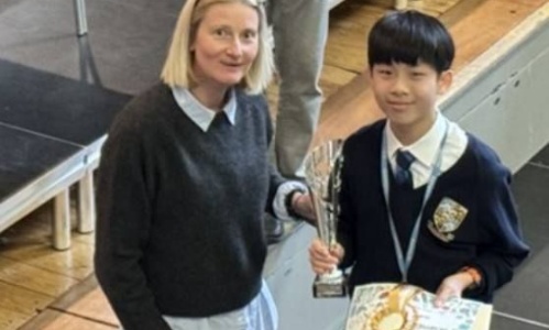 The winner posing with a teacher